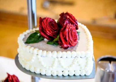 Hochzeitstorte mit roten Rosen dekoriert, fotografiert bei einer Hochzeit in Markt Indersdorf.