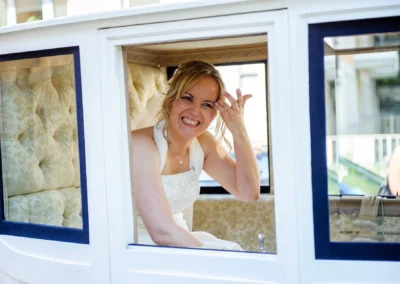 Braut lacht in einer Kutsche in Schwabing, Muenchen bei einer Hochzeitsreportage, aufgenommen vom Hochzeitsfotografen.