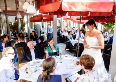 Braut spricht mit Gaesten bei der Hochzeitsfeier im Freien, Wessling, Hochzeitsfotograf.