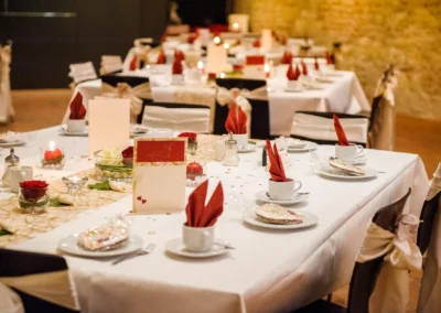 Elegante Hochzeitstafel mit roten Servietten bei Empfang im Schloss Hochstädt an der Donau. Hochzeitsreportage.