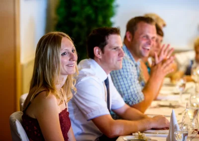 Gäste bei Hochzeitsfeier in Landgasthof Brummer, lächelnd und plaudernd am Tisch, Hochzeitsfotografie.
