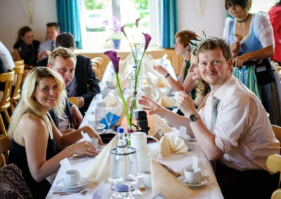 Gedeckter Hochzeitstisch mit Gaesten bei Hochzeitsreportage in Gastwirtschaft Doll, noerdlich von Dachau.