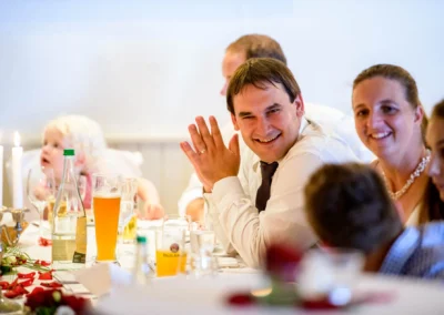 Hochzeitsreportage: Fröhliche Gäste bei einer Hochzeit in Landgasthof Brummer, lachen und genießen das Festessen.