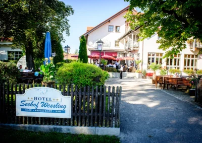 Hotel Seehof Wessling bei einer Hochzeit, Gäste sitzen im Garten. Hochzeitsfotograf für Hochzeitsreportage im Fünfseenland.
