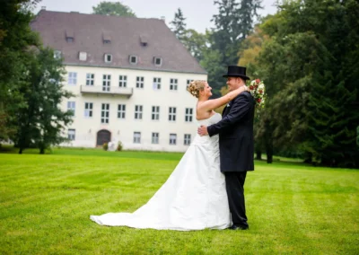 Brautpaar tanzt vor historischem Gebaeude in Miesbach. Hochzeitsfotografie bei einer Hochzeit auf gruenem Rasen.