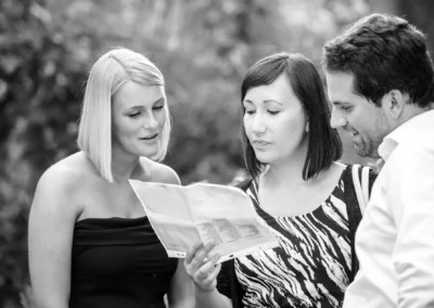 Drei Personen betrachten ein Dokument bei einer Hochzeit im Dachauer Hinterland, Hochzeitsreportage in schwarz-weiß.