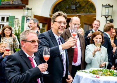 Hochzeitsgesellschaft beim Anstoßen im Freien bei einer Hochzeit im Brauereigasthof Aying.