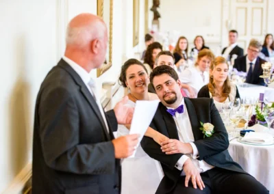 Hochzeitsreportage mit Brautpaar und Gast bei Rede im Palmenhaus Schloss Nymphenburg, Hochzeit München.