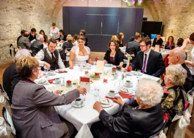 Hochzeitsfoto: Gäste bei Feier im Schloss Höchstädt an der Donau, festlich gedeckter Tisch, Hochzeitsreportage.