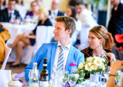 Paar bei Hochzeitsfeier im Palmenhaus Schloss Nymphenburg, Blumen und Gedeck im Vordergrund. Hochzeitsreportage.