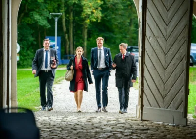 Vier Personen in eleganter Kleidung betreten Schloss Grunau bei einer Hochzeitsreportage nahe Neuburg an der Donau.