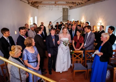 Braut mit Brautstrauss bei der freien Trauung umgeben von Gaesten. Hochzeitsreportage in Schloss Blutenburg, Muenchen.