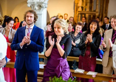 Gäste applaudieren in der Kirche bei einer Hochzeit in Landshut, aufgenommen von einem Hochzeitsfotografen.