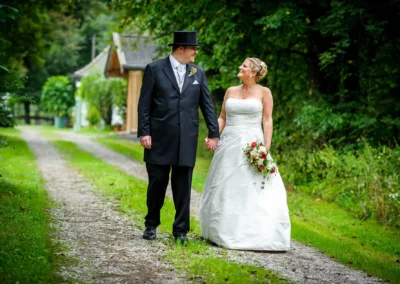 Brautpaar auf Weg im Grünen, Hand in Hand, Bayern, Hochzeitsfoto, Bayerischer Hof Miesbach.