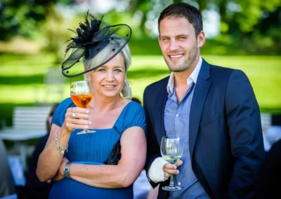 Zwei Hochzeitsgaeste mit Glaesern bei einer Hochzeit auf Schloss Aufhausen bei Erding, festliche Stimmung.