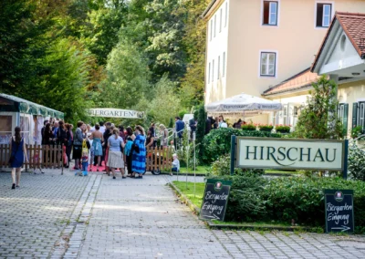 Gäste versammeln sich für eine Hochzeit im Biergarten Hirschau, Schwabing München. Hochzeitsfotografie vor Ort.