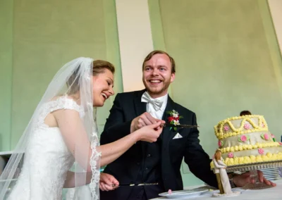 Brautpaar schneidet Hochzeitstorte an. Hochzeitsfotografie in der Orangerie Ansbach.