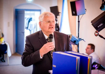 Person haelt Mikrofon bei Hochzeit in Schloss Gruenau, Jagdschloss Gruenau nahe Ingolstadt. Hochzeitsreportage.