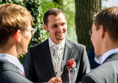 Hochzeitsfoto: Gespräche zwischen Gästen beim Hotel und Restaurant Langwieder See, festliche Anzüge und Sektglas.
