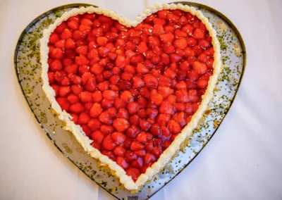 Herzformige Erdbeertorte mit Sahneverzierung, fotografiert bei einer Hochzeit im landgasthof brummer. Hochzeitsfotografie.
