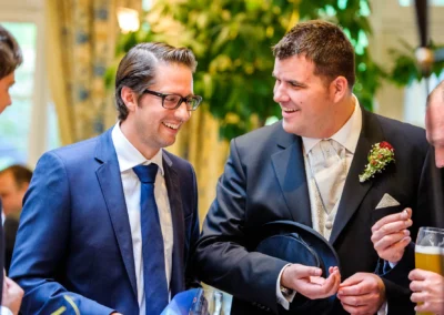 Gäste in eleganter Kleidung bei einer Hochzeit im Bayerischer Hof Miesbach, lachend und mit Getränken in der Hand.