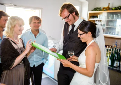 Hochzeitsfoto: Brautpaar liest Karte mit Freunden bei Feier in Markt Indersdorf. Hochzeitsreportage aus München.