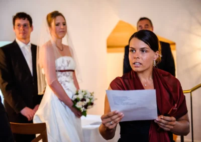 Brautpaar bei freier Trauung in Schloss Blutenburg, Hochzeitsreportage mit Braut in weissem Kleid und Rednerin.