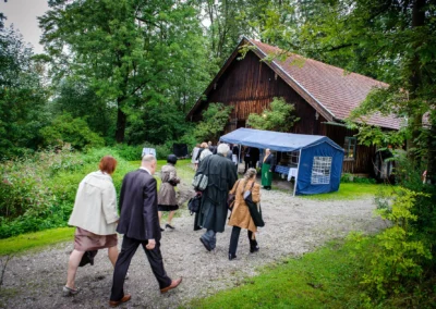 Gaste bei Hochzeitsfeier in Miesbach betreten eine Scheune, aufgenommen von einem Hochzeitsfotografen.