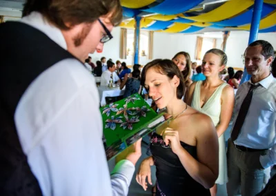 Gäste betrachten Origami auf Tischdekoration bei Hochzeit nördlich von München. Hochzeitsreportage, lächelnde Personen.