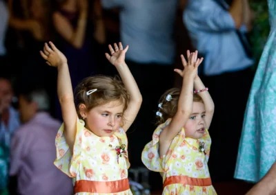 Zwei Mädchen in gelben Blumenmädchenkleidern bei Hochzeit in Trachtenheim Irschenberg. Hochzeitsfoto, Hochzeitsreportage.