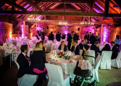 Hochzeitsreportage in der Eventscheune Wallenburg mit Gästen an Tischen in festlich dekoriertem Ambiente.