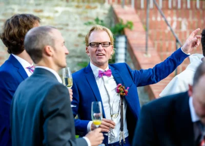 Hochzeitsfoto in Landshut: Manner in Anzug bei der Hochzeit feiern mit Champagner.