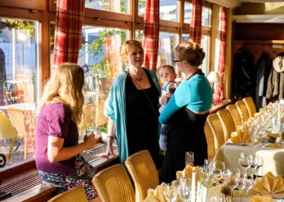 Hochzeitsfotografie: Drei Frauen und ein Baby im Hotel Schloss Berg, festlich gedeckter Tisch im Sonnenlicht.