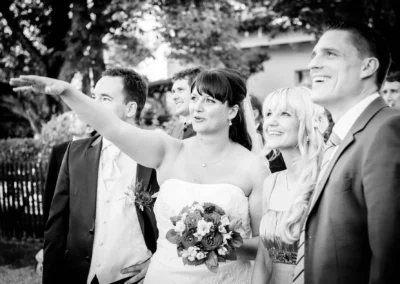Brautpaar und Gaeste betrachten die Umgebung bei einer Hochzeit am Wesslinger See. Hochzeitsfotografie im Freien.