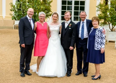Familienportrait bei Hochzeit in Ansbach, Braut und Bräutigam mit Gästen im Garten, Hochzeitsfotografie.