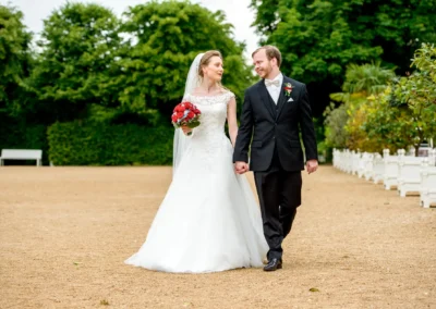 Brautpaar geht Hand in Hand im Hofgarten Ansbach, Hochzeitsfoto aufgenommen von einem Hochzeitsfotografen.