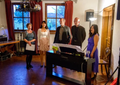 Gruppe von Sängern bei Hochzeitsreportage im alten Wirt Grünwald, neben einem Keyboard stehend.