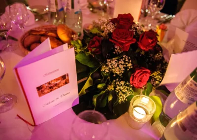 Hochzeitsfoto mit rotem Rosenbouquet und Tischdeko in Eventscheune Wallenburg. Aufnahme von einer Hochzeit.