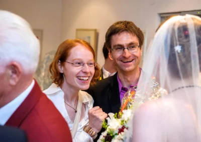Gäste lachen bei einer Hochzeit in München-Obermenzing. Hochzeitsfotografie zeigt freudige Momente.