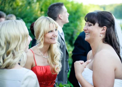Braut lacht mit zwei Frauen bei einer Hochzeit in Wessling, festgehalten von einem Hochzeitsfotografen.