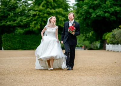 Lachendes Brautpaar bei Hochzeit in Orangerie Ansbach, Braut in weissem Kleid, Bräutigam mit Blumenstrauss.