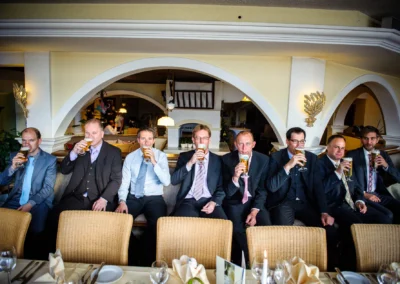 Männergruppe im Anzug trinkt Bier bei einer Hochzeitsfeier am Starnberger See. Hochzeitsfotograf aus München.