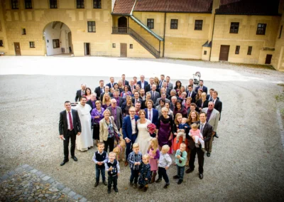 Gruppenfoto bei einer Hochzeitsreportage vor Burg Trausnitz, Hochzeitsgesellschaft in festlicher Kleidung, romantische Kulisse.