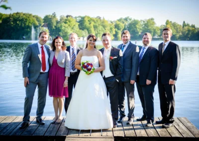 Brautpaar mit Hochzeitsgesellschaft am Wesslinger See auf einem Steg, Hochzeitsfotografie im Landkreis Starnberg.