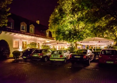 Nachtaufnahme eines Landgasthofs mit Autos, Veranstaltungsort einer Hochzeit in Röhrmoos. Hochzeitsreportage.