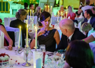 Hochzeitsreportage in Schwabing, Muenchen: Gaeste bei romantischem Kerzenlicht am Tisch bei der Hochzeit.