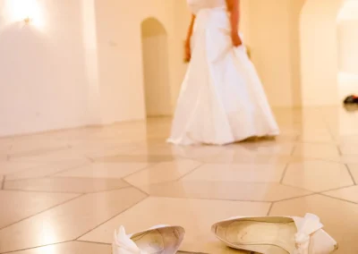 Braut in weissem Kleid ohne Schuhe in Schloss Hoechstaedt an der Donau, Hochzeitsfoto mit Fokus auf die Schuhe.