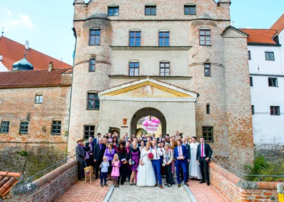 Hochzeitsgesellschaft vor historischem Gebaeude in Landshut waehrend einer Hochzeit, aufgenommen von Hochzeitsfotograf.