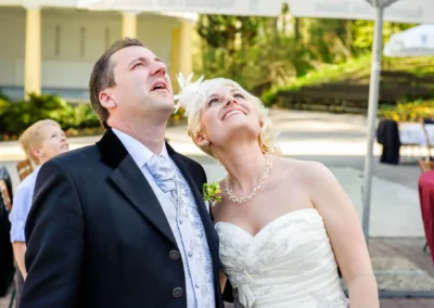 Brautpaar schaut nach oben bei einer Hochzeit im Freien. Hochzeitsfotografie in Bad Toelz, suedlich von Muenchen.