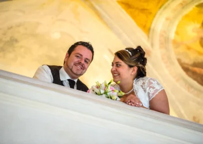 Brautpaar laechelt auf Balkon im Schloss Hochstaedt, nahe Dillingen. Hochzeitsfotografie von Hochzeitsportraits.